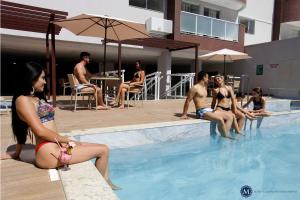 a group of people sitting in a swimming pool at Everest Flat Service in Caldas Novas