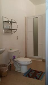 W łazience znajduje się biała toaleta i lustro. w obiekcie Teocalli w mieście Teotitlán del Valle