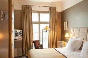 a hotel room with a bed and a window at Hôtel Thérèse in Paris