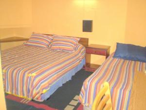 Habitación de hotel con 2 camas y escritorio en Hotel Capric, en Viña del Mar