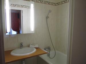 a bathroom with a sink, mirror, and bath tub at Hôtel De Nice in Paris
