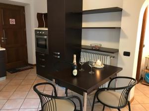 グラヴェドーナにあるBeautiful lake view apartment in Gravedona - Larihome A01のキッチン(ワインボトルと椅子付きのテーブル付)
