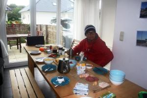 a man sitting at a table with food on it at Piratennest Ferienwohnung in Dranske