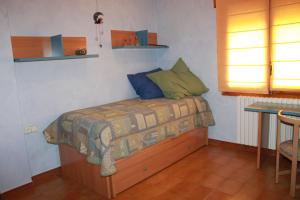 a small bedroom with a bed and a table at CA L'AMPURDANES in Alcoletge