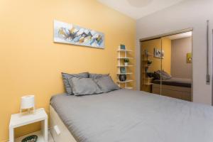 a bedroom with a large bed and a mirror at Beach Houses in Costa da Caparica