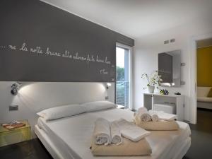 1 dormitorio con 1 cama con toallas en Gardabike Residence, en Nago-Torbole