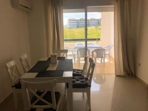 een eetkamer met een tafel en stoelen en een raam bij SeaView Appart Chez Hicham in Asilah