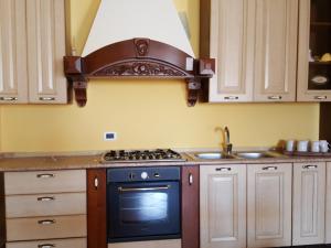 a kitchen with a stove and a sink at A Due Passi Dal Mare in Petrosino