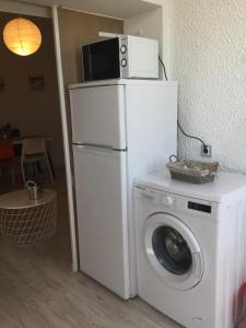 a washing machine with a microwave on top of it at Beach Houses in Costa da Caparica