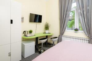 ザグレブにあるAnastasia Suites Zagrebのベッドと机と窓のある寝室