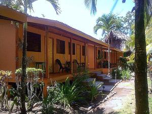 ein Haus mit Palmen davor in der Unterkunft Cabinas Sol y Mar in Zancudo