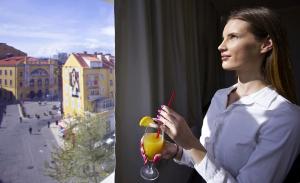 a woman is holding a drink with a straw at Prima Luce Downtown - MAG Quaint & Elegant Boutique Hotels in Split