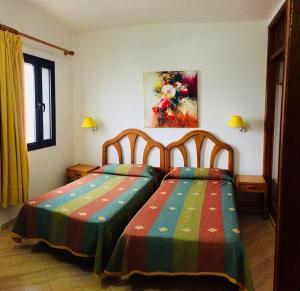 a bedroom with two beds with colorful blankets at Apartamentos Maribel in Puerto del Carmen +18 photos