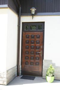 a wooden door on a house with a potted plant at Willa Kasztelańska in Porąbka