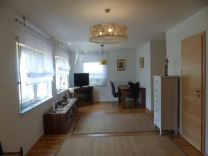 a living room with a table and a desk with a computer at Pension Temizdemir in Lahr