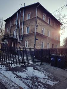 een oud gebouw met een hek ervoor bij Apartament Szczawno-Zdrój in Szczawno-Zdrój