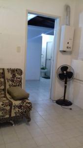 Apartamento kitchenette في ساو لورينسو دو سول: غرفة بها كرسي ومصباح على الأرض