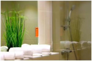 a bathroom with a shower with a plant in it at Motel Plus Berlin in Berlin