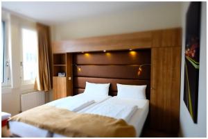a bedroom with a large bed with a wooden headboard at Motel Plus Berlin in Berlin