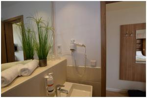 a bathroom with a shower and a sink and a mirror at Motel Plus Berlin in Berlin