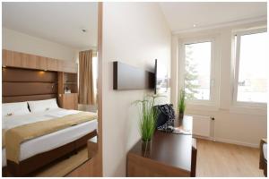 a bedroom with a bed and a tv on a wall at Motel Plus Berlin in Berlin