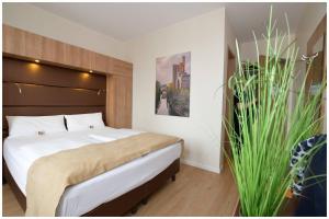 a bedroom with a large bed and a plant at Motel Plus Berlin in Berlin