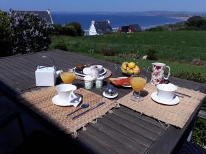 uma mesa de piquenique com um pequeno-almoço de café e frutas em Guest house Chante vent em Douarnenez