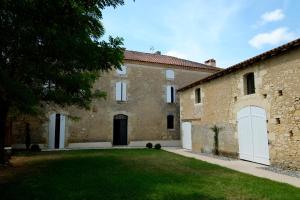 een groot bakstenen gebouw met een grasveld bij Maison Breton in Biran