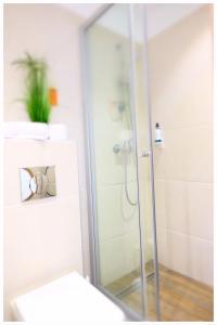 a shower with a glass door in a bathroom at Motel Plus Berlin in Berlin