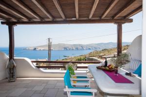 un patio con tavolo, sedie e vista sull'oceano di Villa Alba Mykonos ad Agios Sostis Mykonos