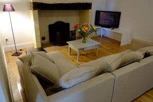 een woonkamer met een bank en een tafel met bloemen bij Maison Breton in Biran