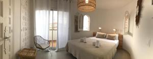 a bedroom with a bed and a chair and a window at Casa Acacia Mar in Cambrils +62 photos