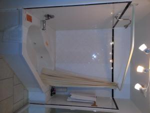 estante de cristal en el baño con toallas en Holiday Motel, en Orillia