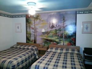 a bedroom with two beds and a painting on the wall at Holiday Motel in Orillia