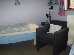 ein Schlafzimmer mit einem Bett und einem Stuhl darin in der Unterkunft Glyngøre Bed & Breakfast in Glyngøre