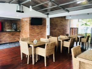 a dining room with tables and chairs and a tv at Hotel Toscana Oriente in Rionegro