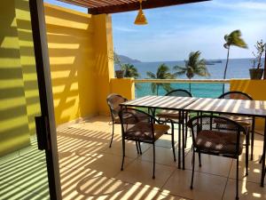 a balcony with a table and chairs and the ocean at Andressa Mia Apartments in Manzanillo