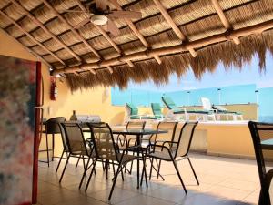 a dining room with a table and chairs and a boat at Andressa Mia Apartments in Manzanillo