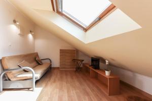 a attic room with a skylight and a couch at Relaxing Guesthouse - Sónias Houses in Lisbon