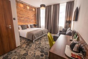 a hotel room with a bed and a living room at Hotel Lavender in Kraków