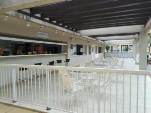a balcony with chairs and tables and a building at Condomínio Aldeia dos Reis in Mangaratiba