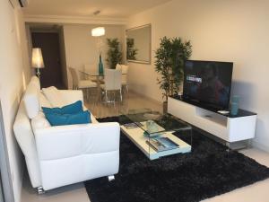 sala de estar con sofá blanco y TV en Look Brava, en Punta del Este
