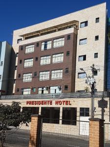 un gran edificio de ladrillo con un cartel. en Presidente Hotel, en Poços de Caldas