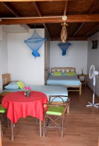 a room with two beds and a table and chairs at La Pachamama in Máncora