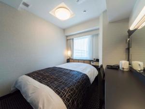 um quarto de hotel com uma cama e uma janela em APA Hotel Higashi-Umeda Minami-morimachi-Ekimae em Osaka