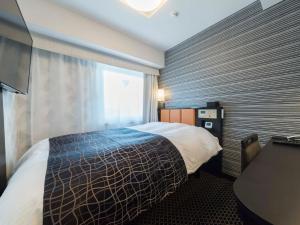 um quarto de hotel com uma cama e uma janela em APA Hotel Higashi-Umeda Minami-morimachi-Ekimae em Osaka