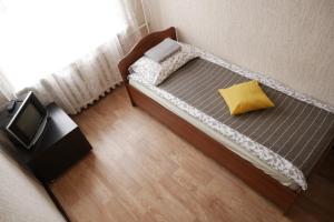 1 cama pequeña con almohada amarilla en una habitación en City Hostel, en Novosibirsk