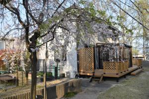 a house with a tree with white flowers on it at Minpaku Momotaro Bekkan in Kasugai