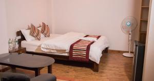 1 dormitorio con 1 cama con ventilador y mesa en k2Homes, en Pātan
