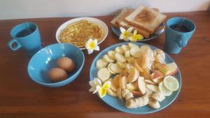 a table with plates of food and eggs and toast at Gede's Homestay in Tejakula
